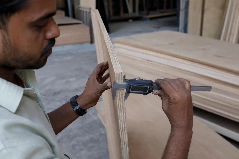 Illustrative plywood edge thickness and condition inspection with a caliper in Gurugram