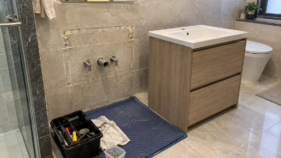 An intact tiled bathroom prepared for a vanity replacement without needless demolition